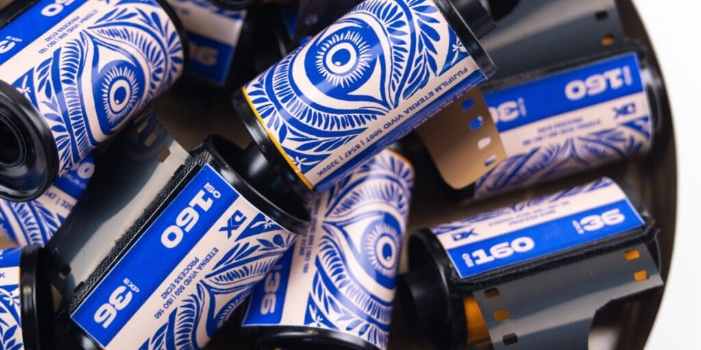 Fuji Eterna Vivid 160 daylight-balanced film rolls with blue labels and eye-like patterns, some partially unspooled.